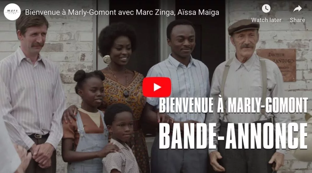 Screen capture from french film Bienvenue a Marly Gomont, a film about racism, showing a black family temidden white people